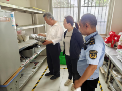 工做人员认实查抄餐具消毒设备运转环境